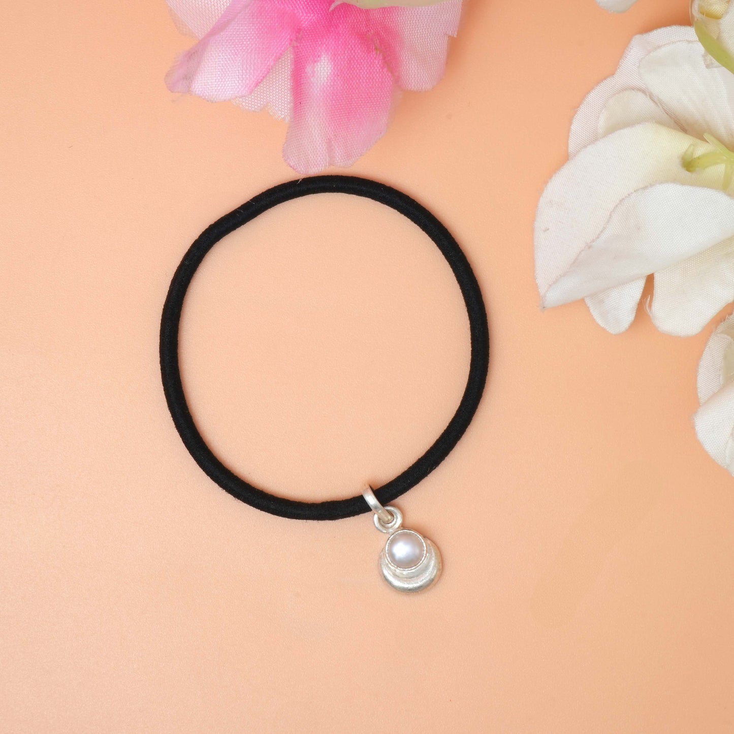 A Black/pink string bracelet featuring a delicate silver charm