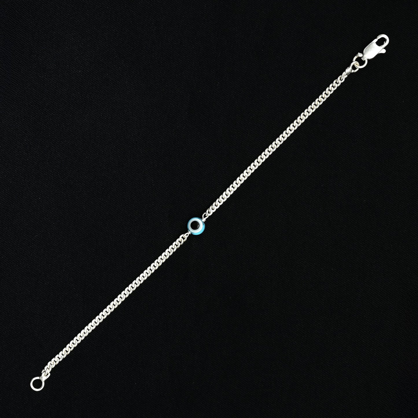 Elegant silver bracelet featuring a light blue evil eye for protection.