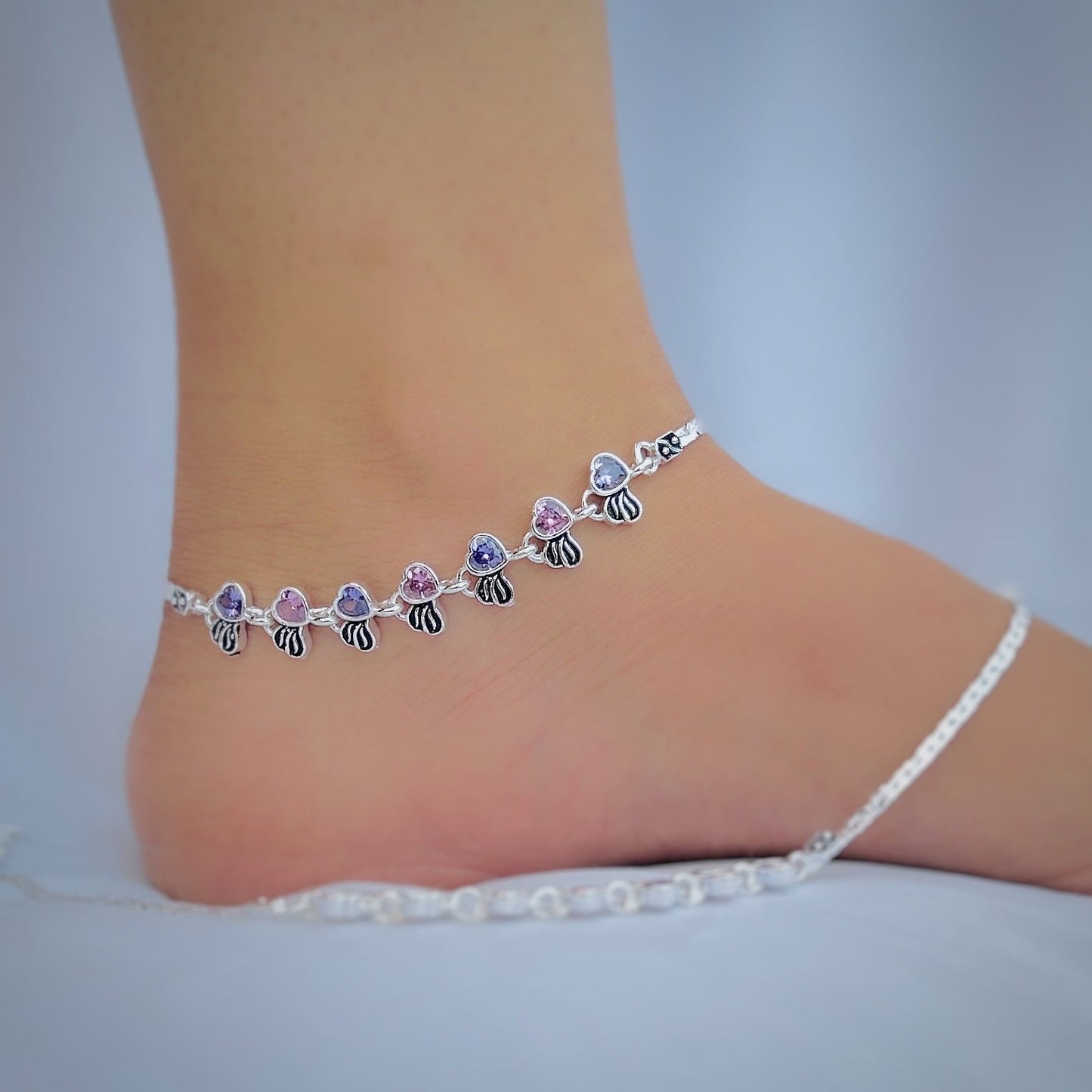 Fashionable silver anklet featuring stunning heart-shaped pink and blue stones.